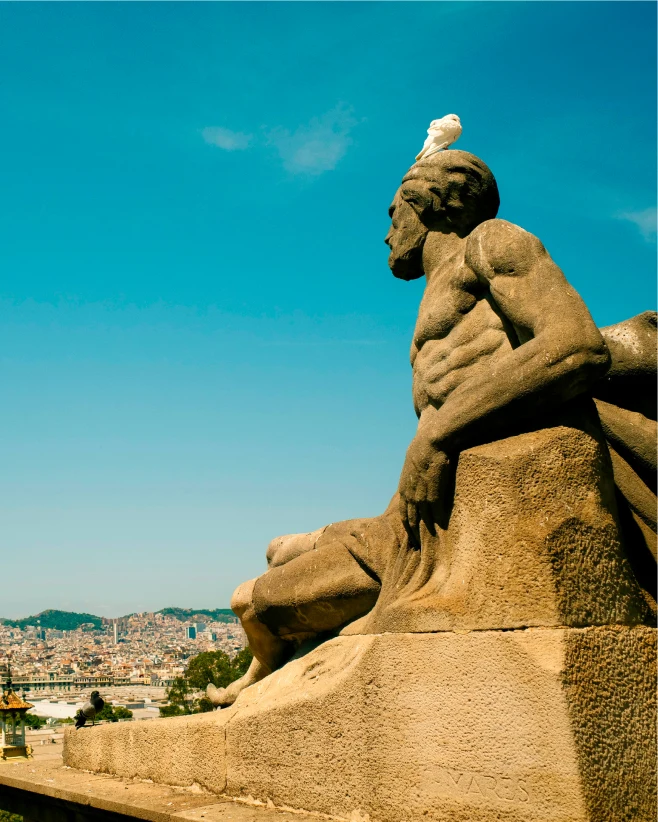 Stone statue with a pigeon on its head overlooking the city