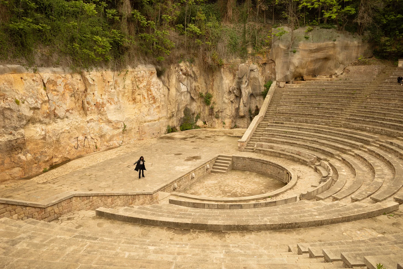 Person walking through a curved open-air theatre