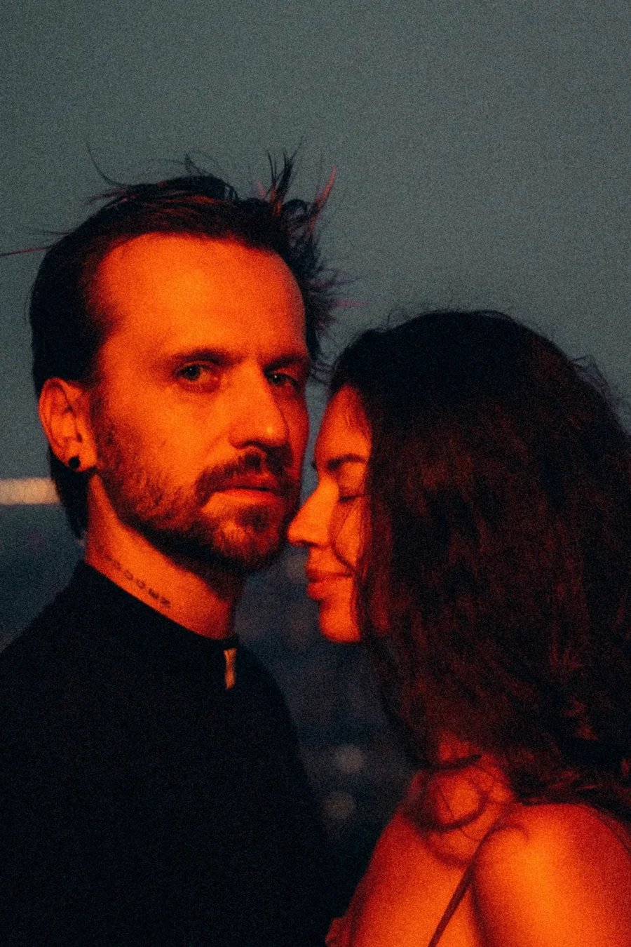 Close portrait of a couple illuminated by warm red light