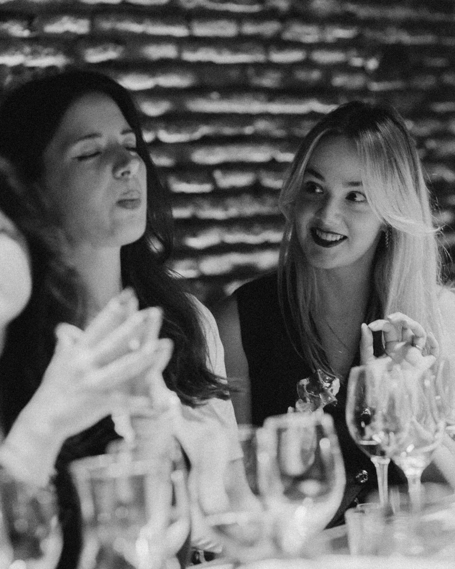 Guests smiling and talking over wine at a private celebration