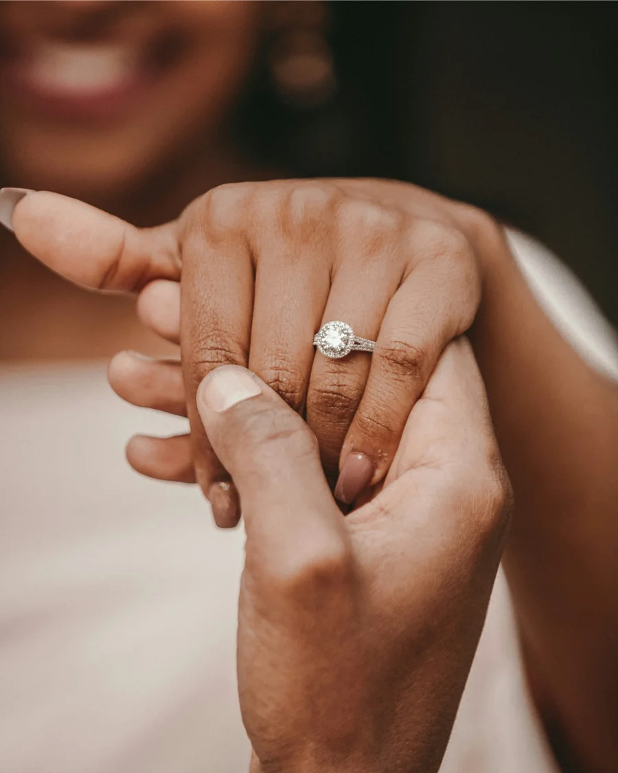 Close-up of hands displaying an engagement ring